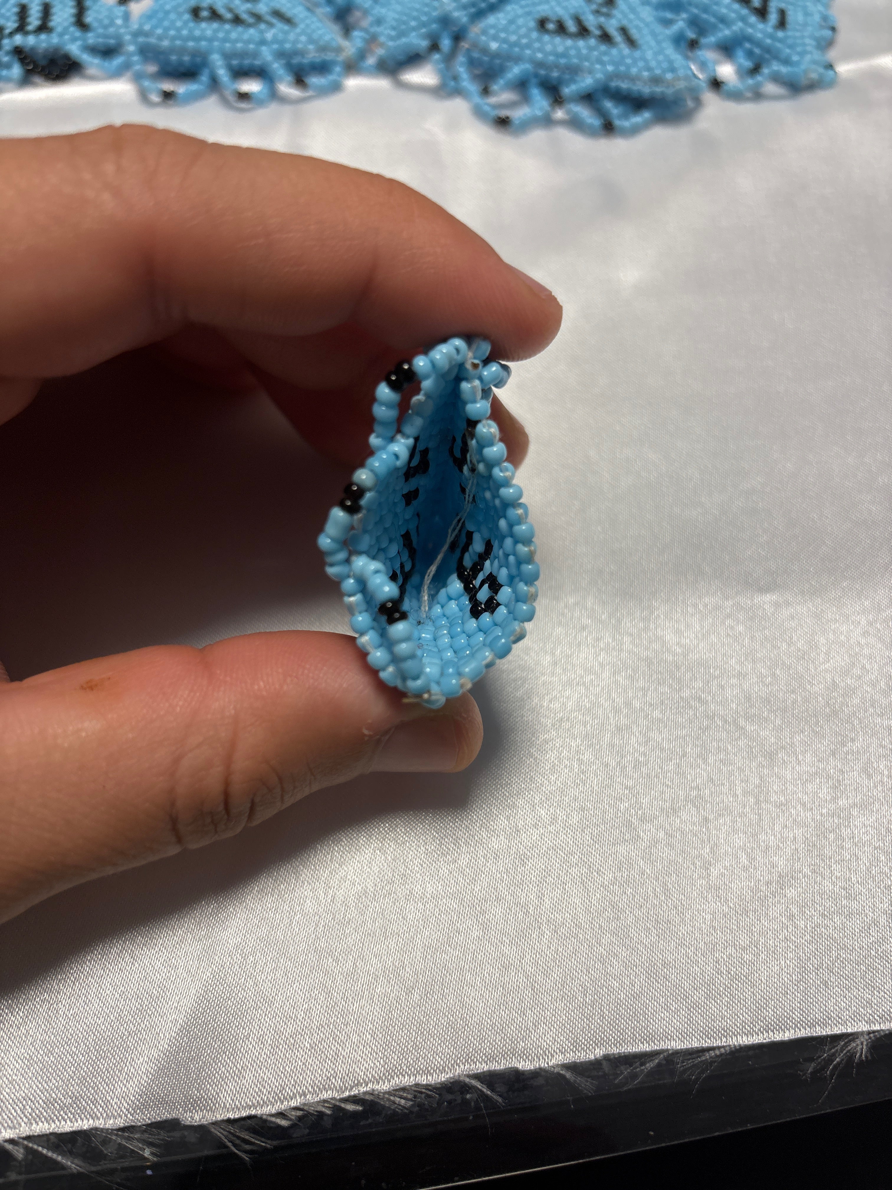 Handgefertigtes Hellblaues Perlenamulett mit Kalligraphie